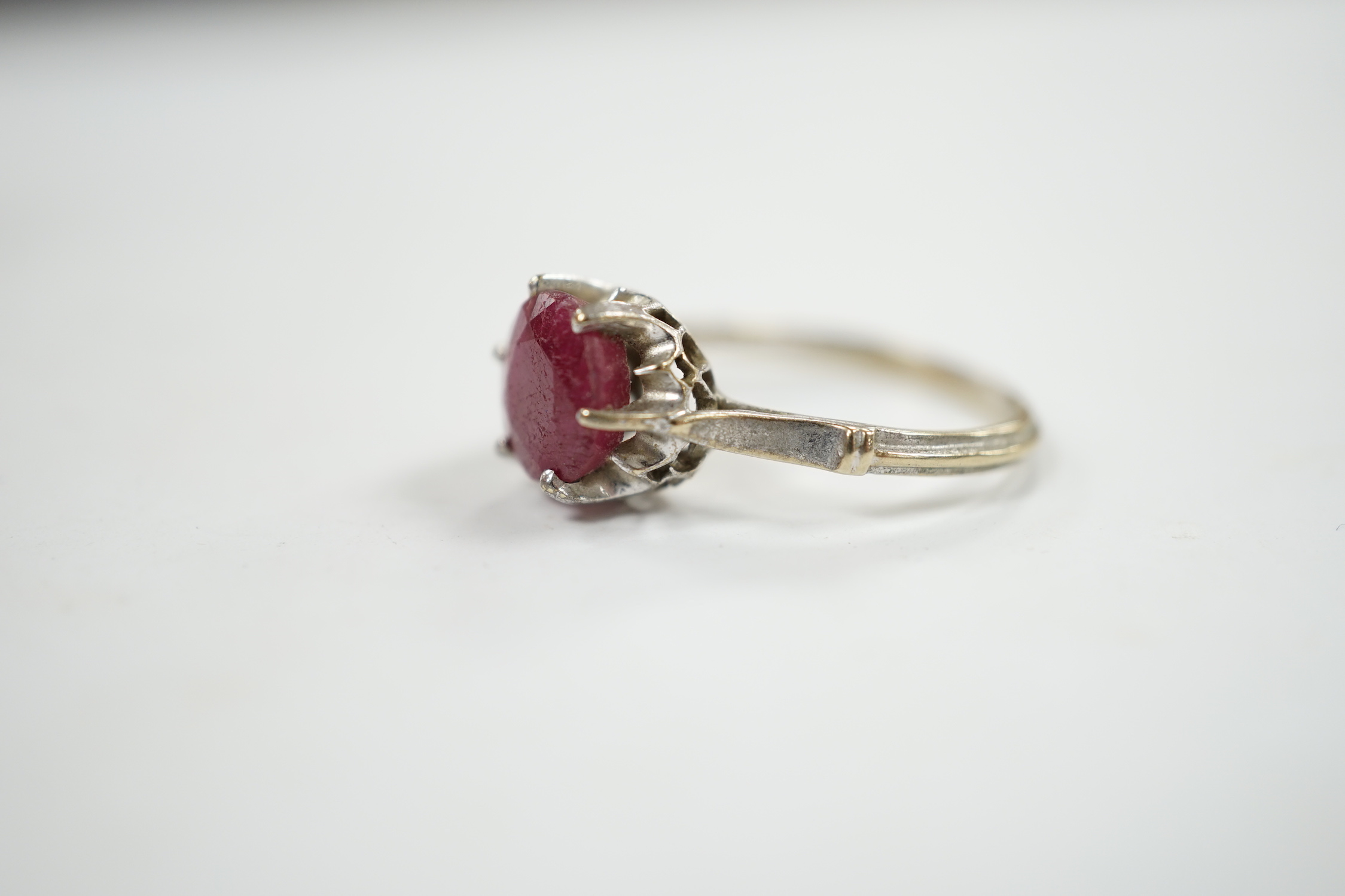 A 750 white metal and solitaire ruby set ring, size M/N, gross weight 3.1 grams.
